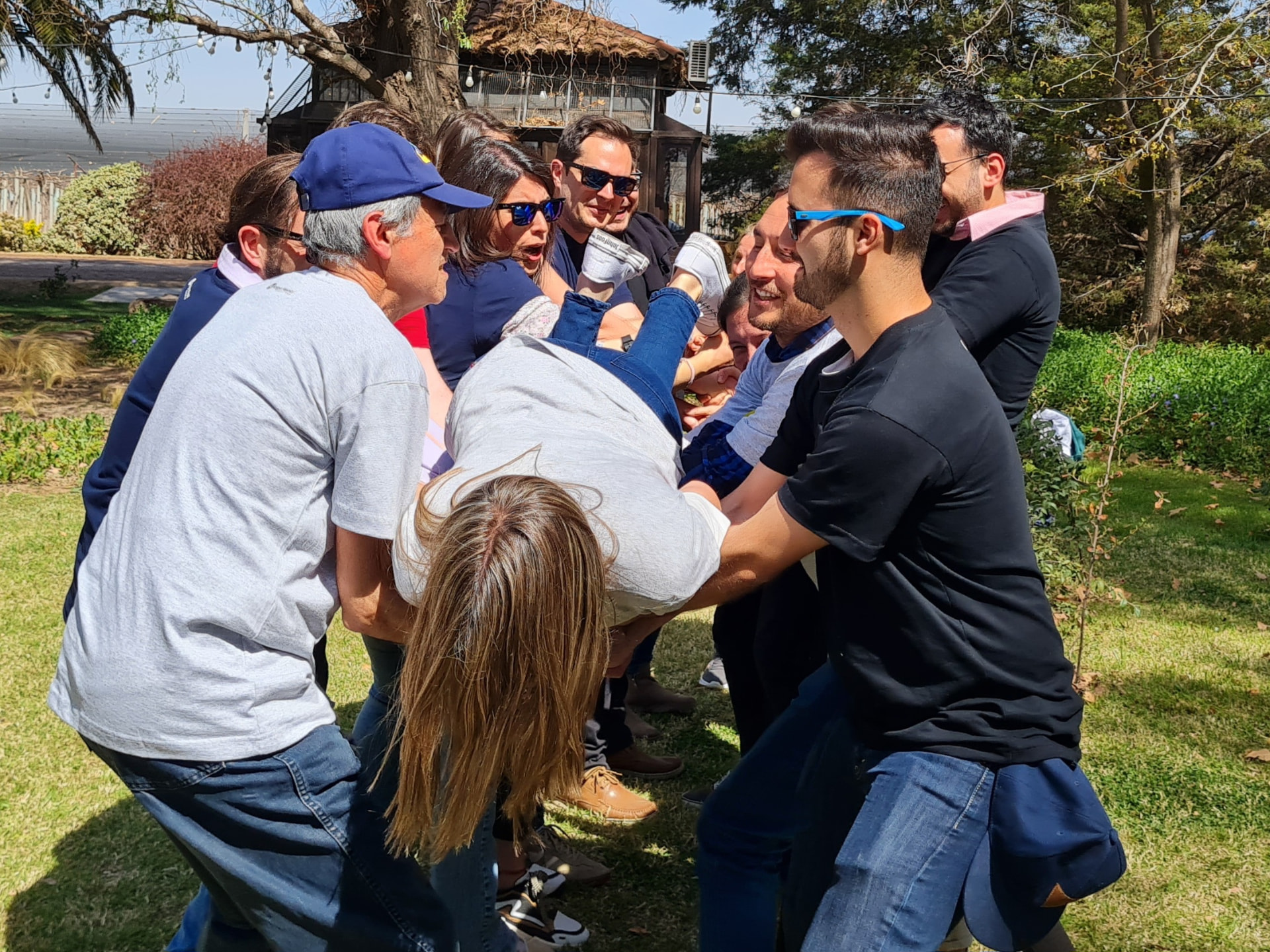 Participantes sosteniendo a una compañera durante un juego de confianza